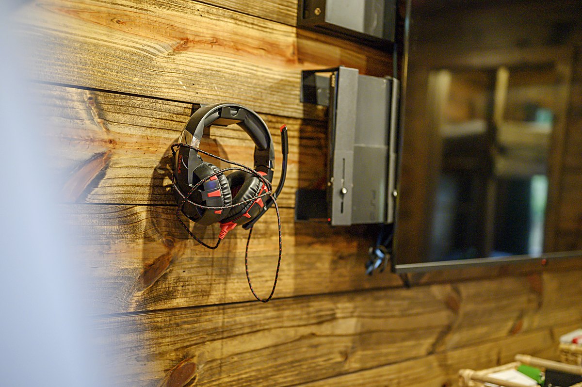 Gaming headsets hanging by the TV